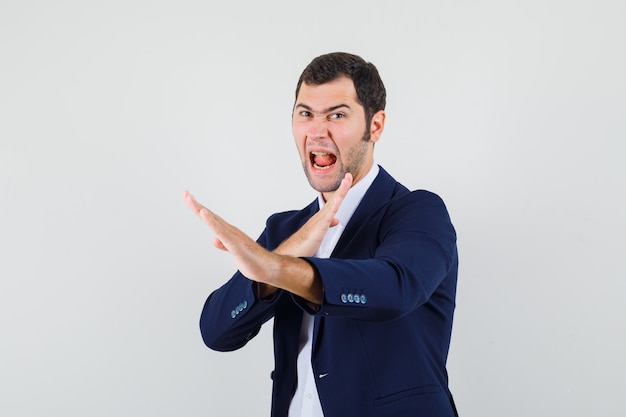 Young male showing karate chop gesture in shirt