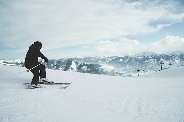 Free photo a young male skiing on the mountains covered in the snow