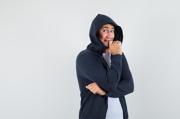 Free Photo young male standing in thinking pose in t-shirt, jacket and looking excited , front view.