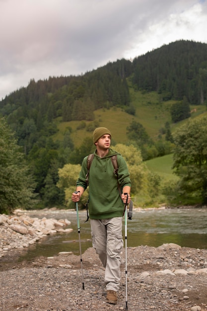 Free photo young male traveler enjoying rural surroundings