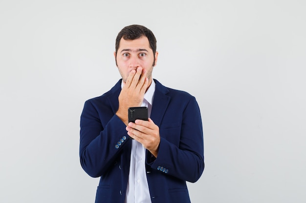 Young male using mobile phone in shirt