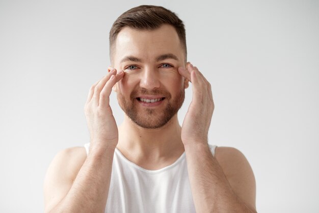 Young man applying his anti aging treatment