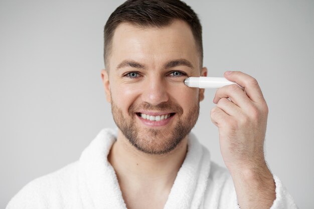 Young man applying his anti aging treatment