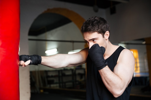 Free Photo young man boxer training with punchbag