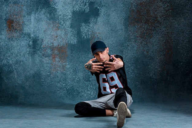 Free photo young man break dancing on wall.