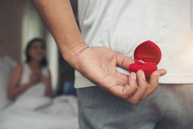 Free photo young man bringing ring box for his girlfriend at his home