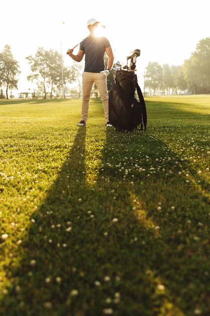 Young man in cap holding golf club