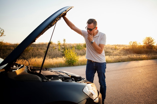 Young man checking the car engine