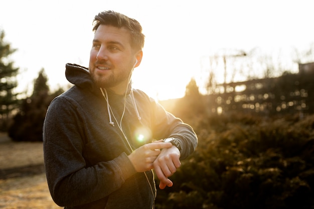 Young man checking his smartphone while exercising outdoors