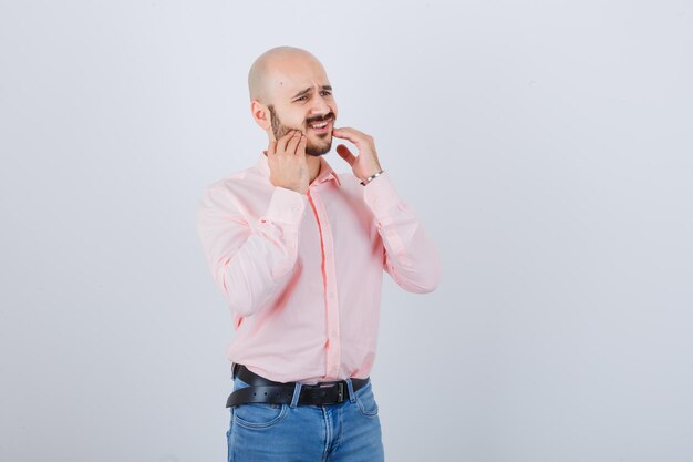 Young man checking skin by touching his beard