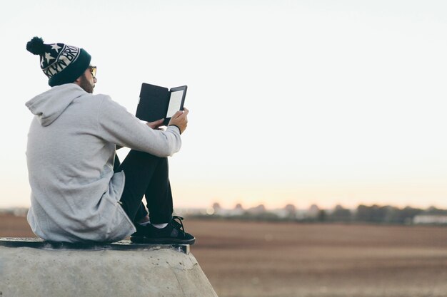 Young man chilling with tablet on nature