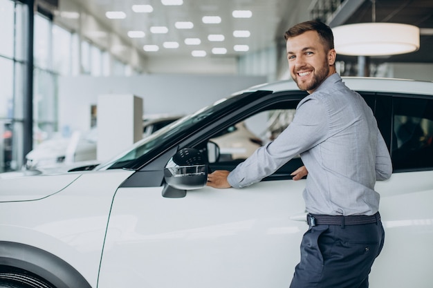 Young man choosing a car in a car salon