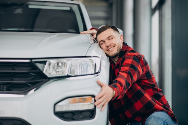 Young man choosing a car in a car showroom