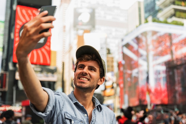 Free photo young man in city taking selfie