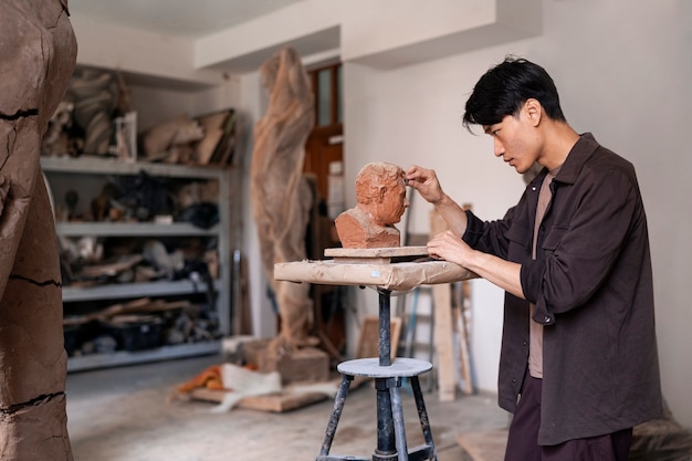 Young man clay sculpting medium shot