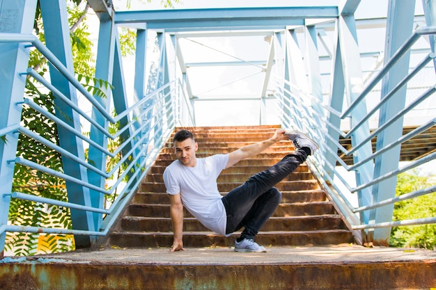 Young man dancing on bridge