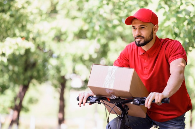 Young man delivering parcel on a bike