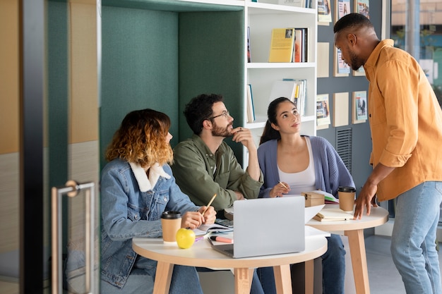 Free photo young man discussing with his colleagues during study session