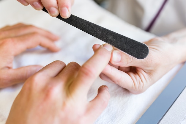 Free photo young man doing manicure in salon. beauty concept.