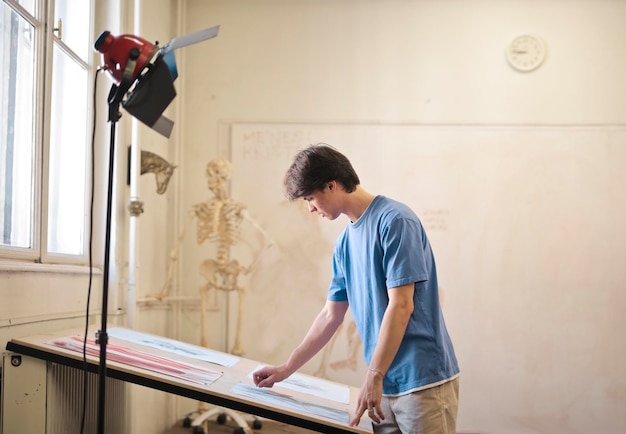 young man draws a skeleton in school