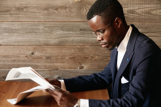 Young man dressed in formal suit sitting in cafe