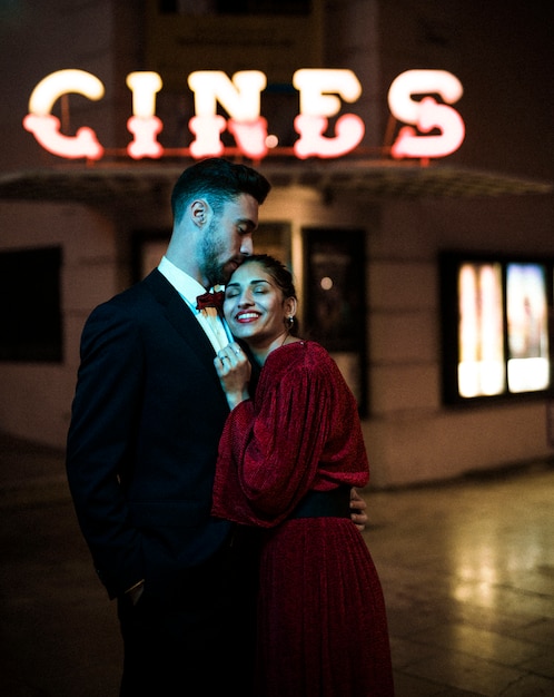 Young man embracing charming attractive happy woman on street