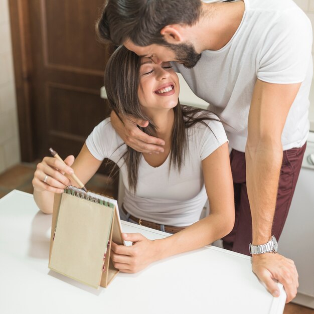 Young man embracing writing girlfriend