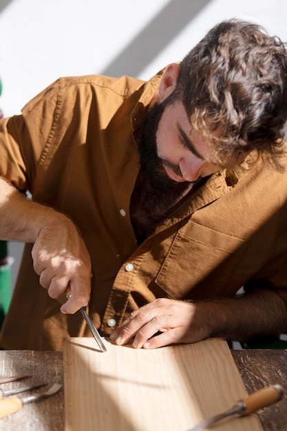 Free Photo young man engraving in wood