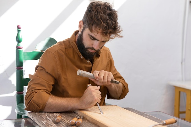 Free photo young man engraving in wood