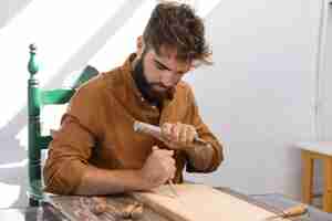 Free photo young man engraving in wood