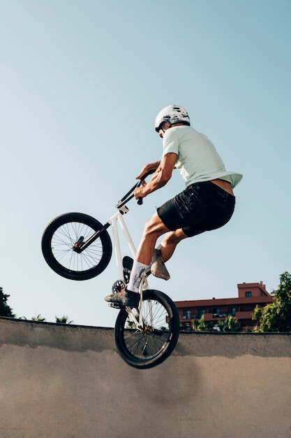 Free photo young man extreme jumping  with bicycle