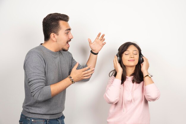 Young man feeling angry about constant noise coming from woman.