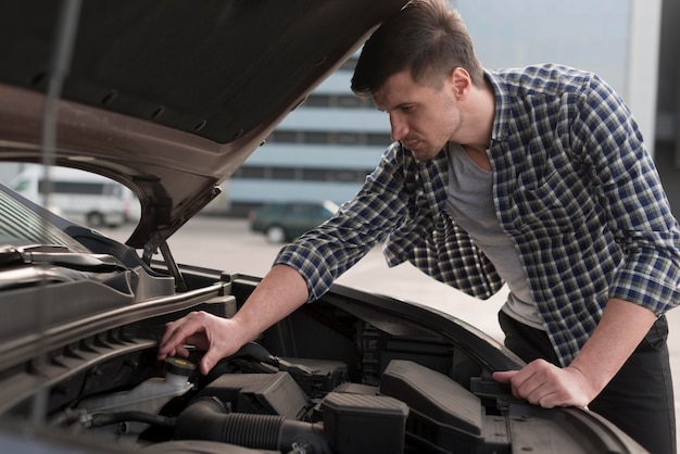 Free Photo young man fixing car