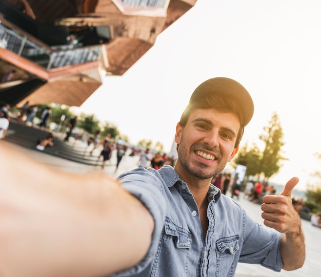 Free photo young man gesturing smiling at camera