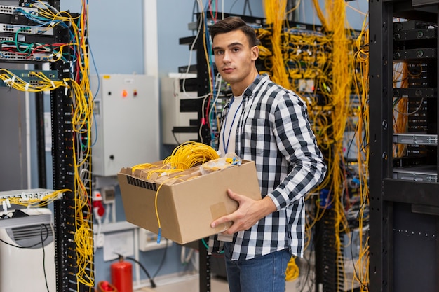 Free Photo young man holding a box with wires medium shot