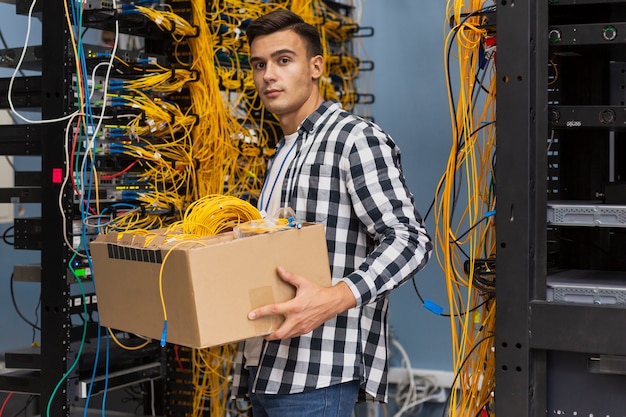 Free Photo young man holding a box with wires