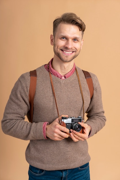 Free Photo young man holding camera for traveling