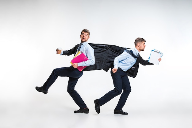 Young man holding folders and documents on the run in different directions