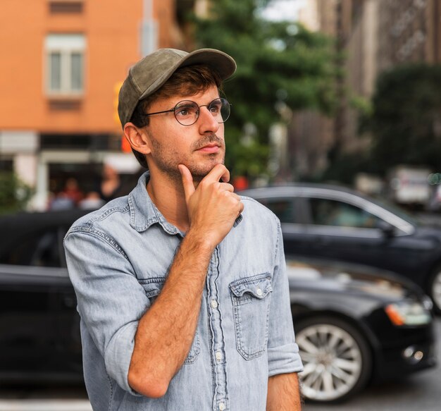 Young man holding his hand under his beard