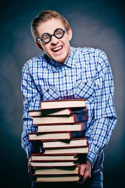 Free photo young man holding many books