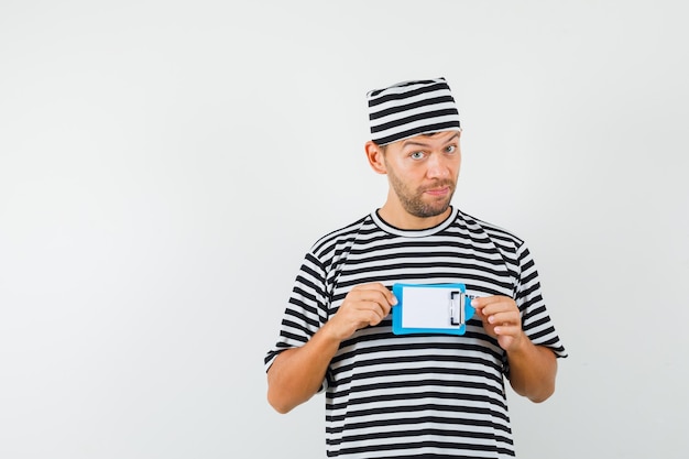 Free photo young man holding mini clipboard in striped t-shirt hat