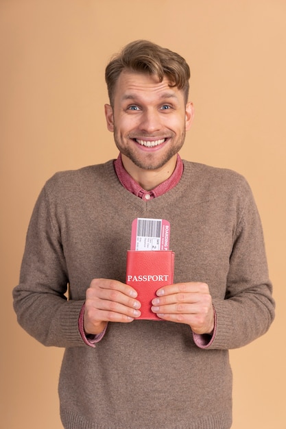 Young man holding passport and plane tickets for traveling