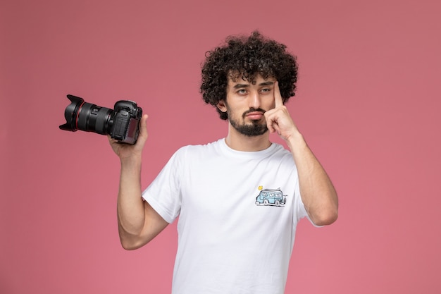 Free photo young man holding photocamera and thinking deeply