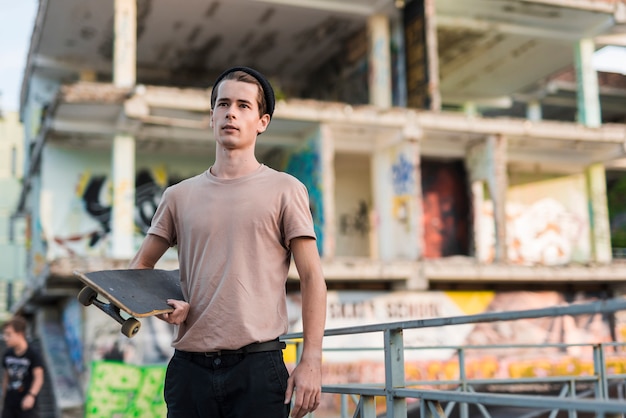 Free photo young man holding a skateboard