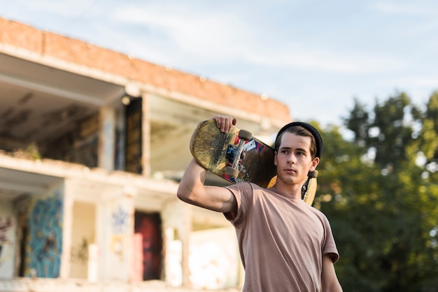 Free photo young man holding a skateboard