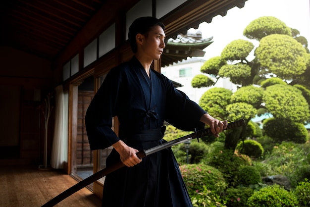 Free Photo young man holding sword side view