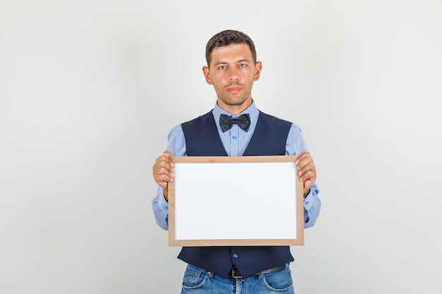 Free photo young man holding white board in suit