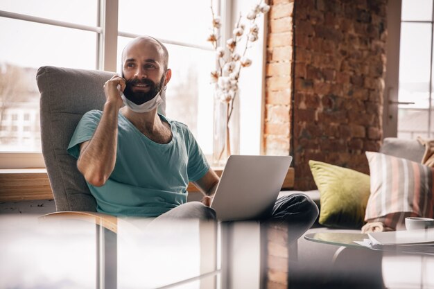 Young man at home while being on quarantine and freelance working