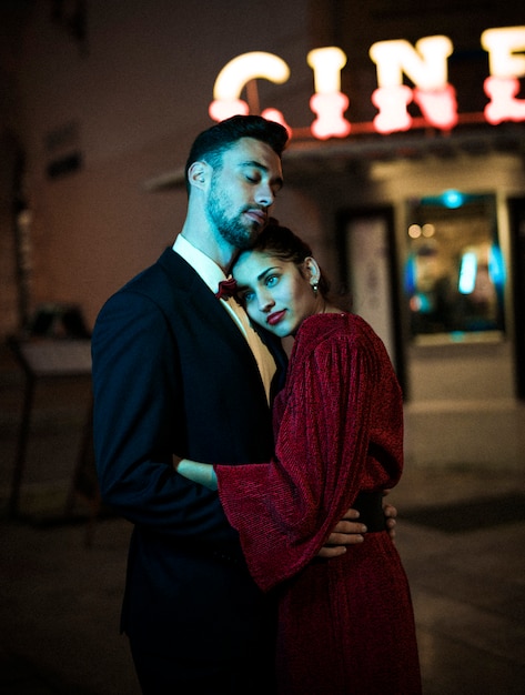 Young man hugging charming attractive pensive woman on street