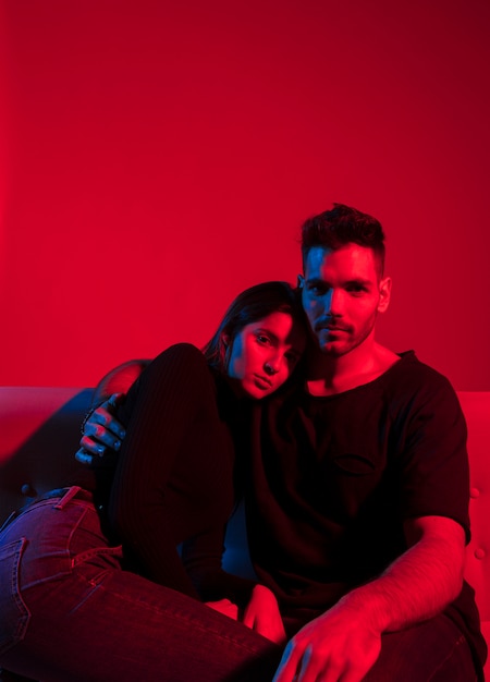 Young man hugging pretty woman on couch